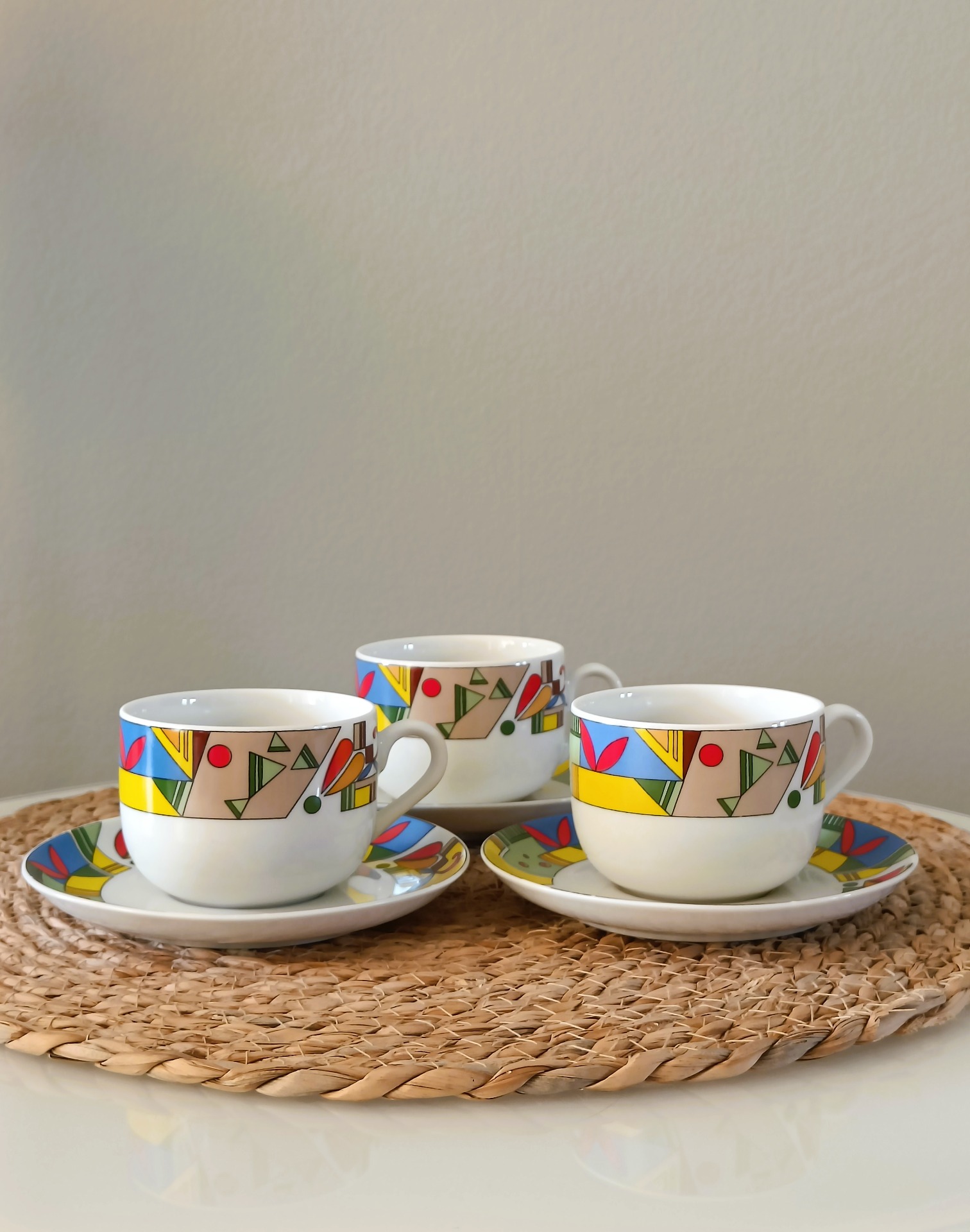 Drie witte vintage mokken met kleurrijk geometrisch patroon op schotels van Jarolina - DE